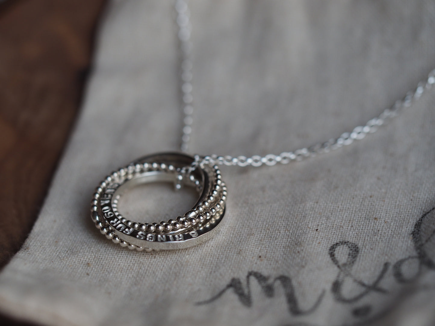 personalised silver ring necklace on a branded bag