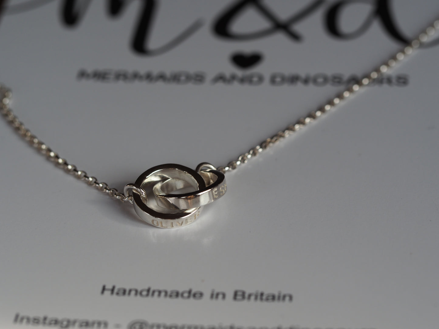 A silver interlinked chunky ring necklace on a branded card, indicating it is handmade in Britain.