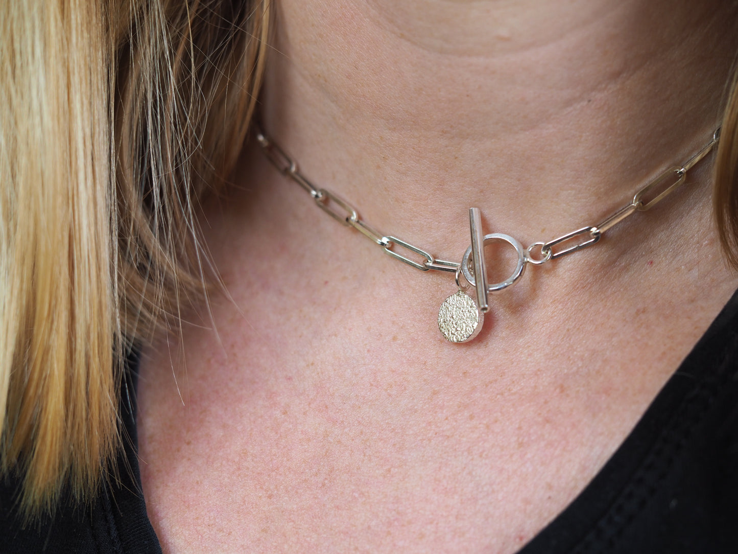 silver paperclip necklace being worn around neck