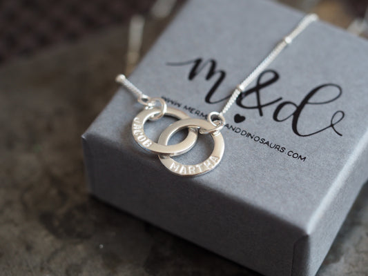 Silver necklace with interlocking rings on a branded box