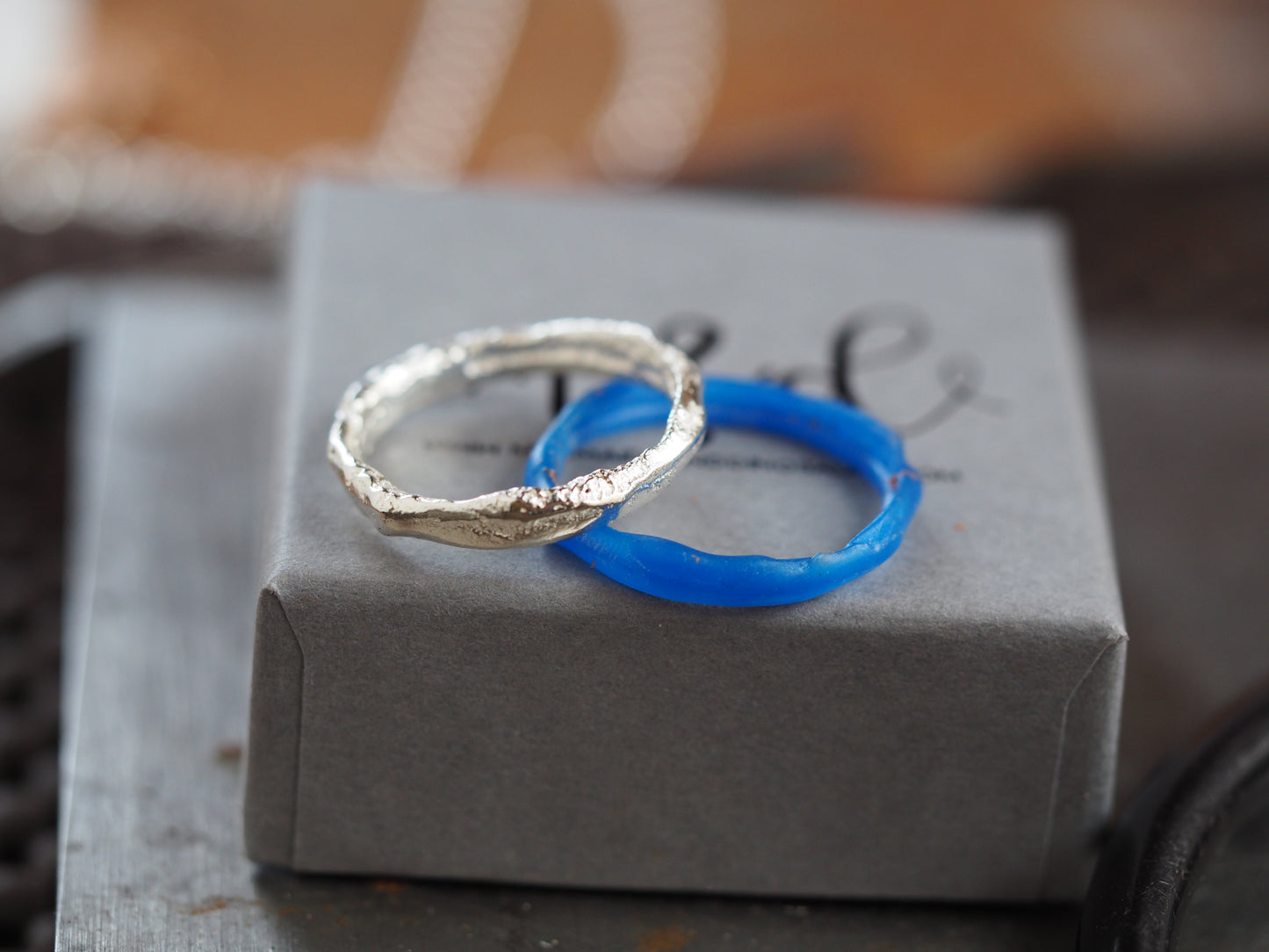 Silver and blue wax ring on a gray box with blurred background