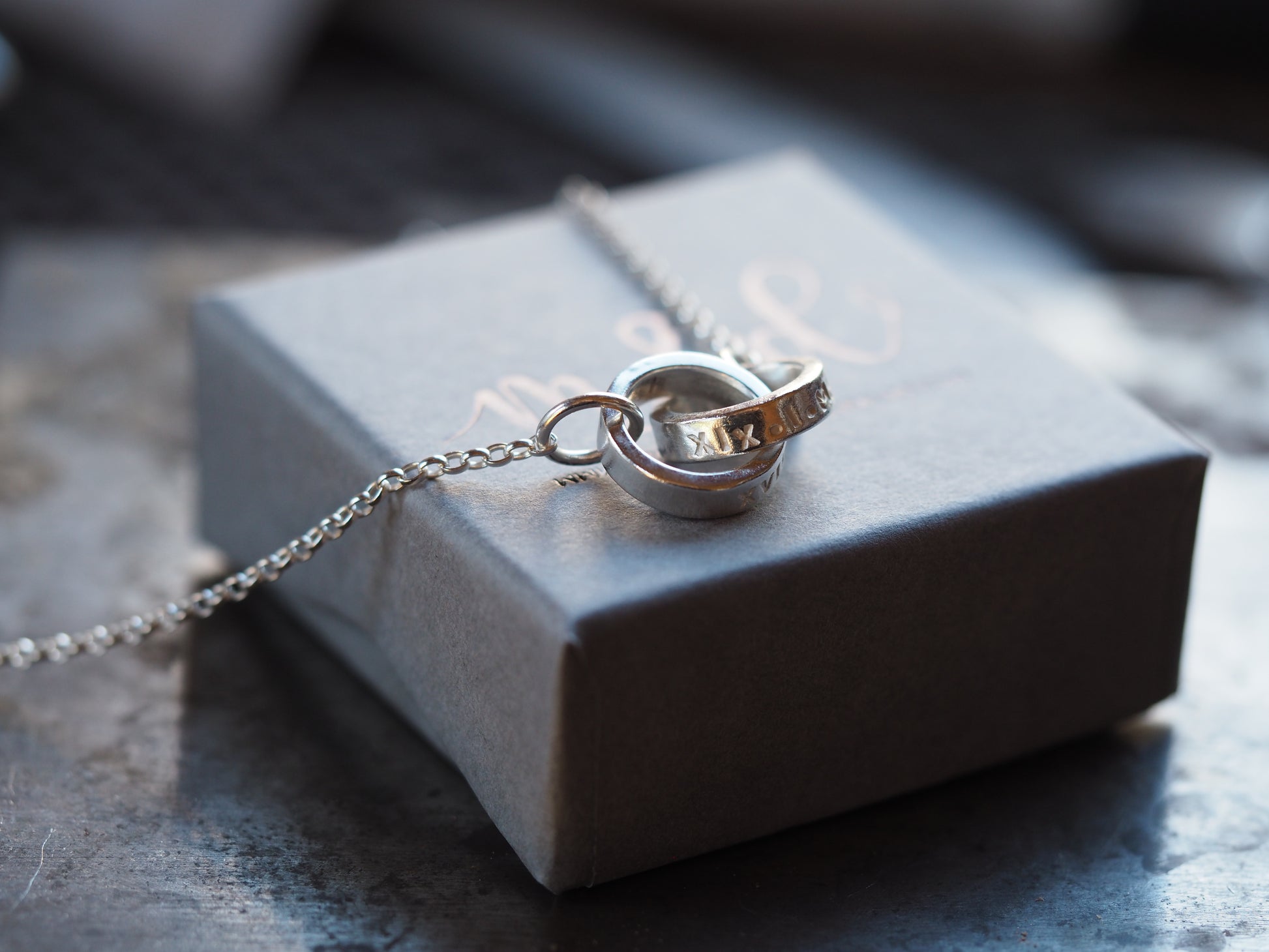 shiny silver interlinked ring necklace personalised with roman numerals