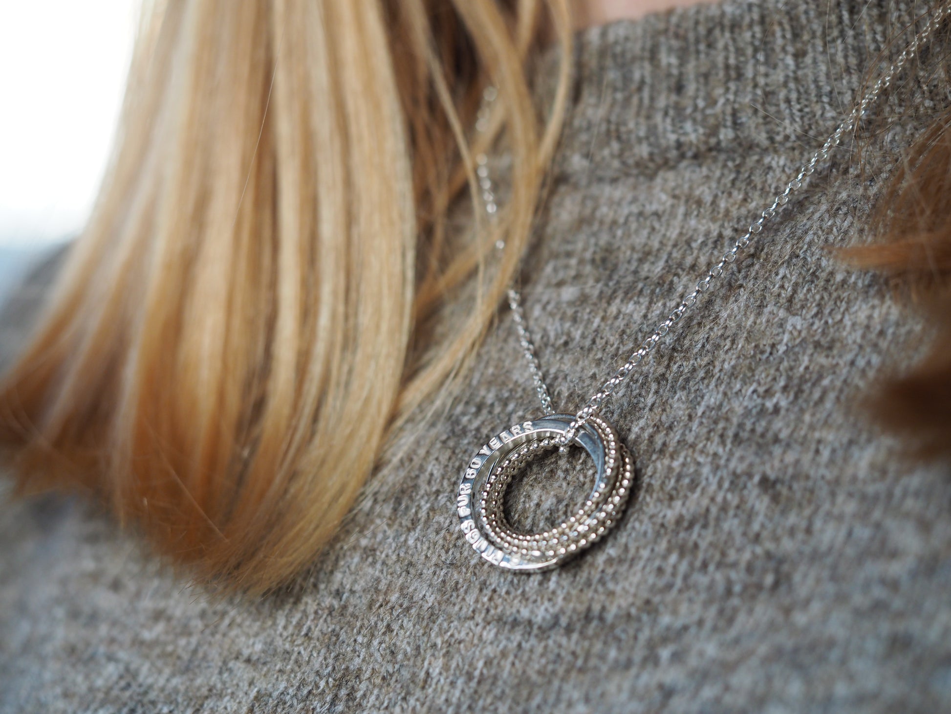 silver interlocking necklace being worn